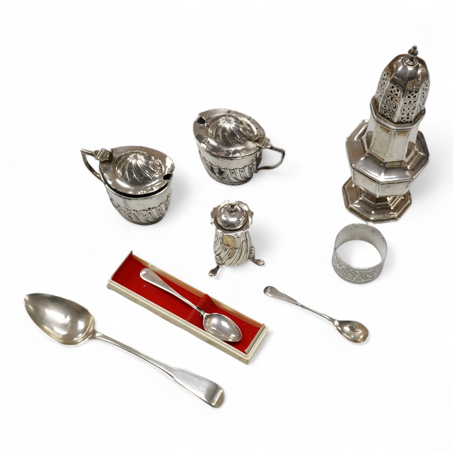 A George V silver octagonal sugar caster, Viners Ltd, Sheffield, 1932, 18.2cm, an Edwardian silver three piece condiment set by John Round, a silver napkin ring and three silver spoons including a dessert spoon by Peter,